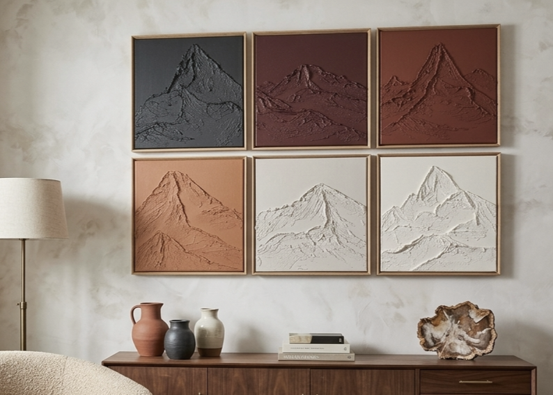 Set of six framed mountain landscapes on a wall above a wooden console table.